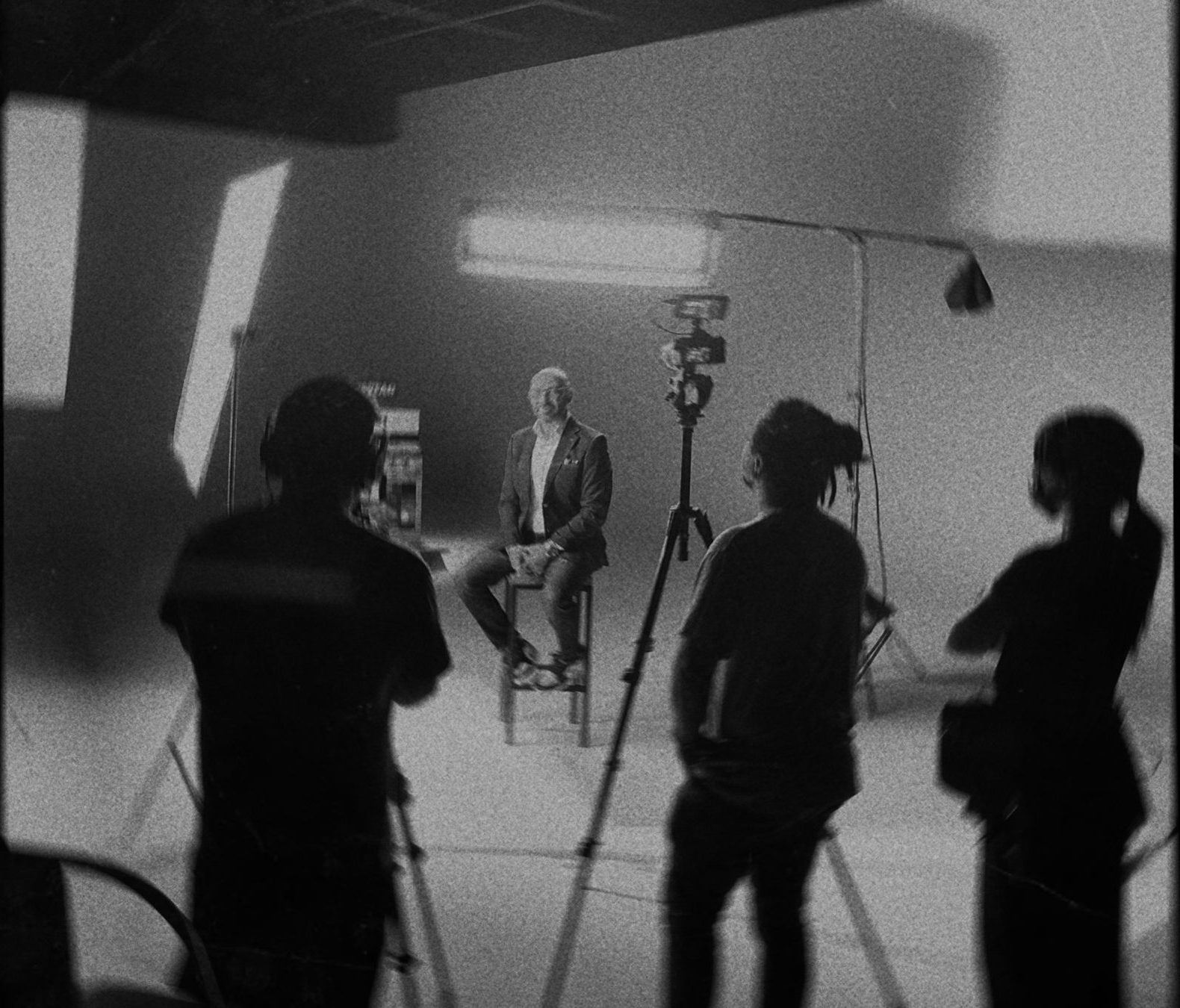 Film crew in a studio facing an interviewee